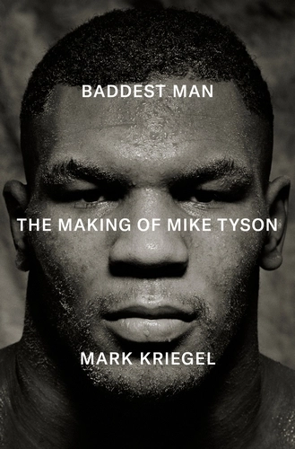 The book cover for Baddest Man: The Making of Mike Tyson by Mark Kriegel. The image is a dramatic, black-and-white close-up portrait of a young Mike Tyson, his face glistening with sweat, expression intense and stoic. The lighting casts deep shadows across his strong features, emphasising the contours of his jaw and brow. The title text is placed in bold white capital letters across his forehead and cheeks: “BADDEST MAN.” Beneath that, centred over his nose and mouth, it reads: “THE MAKING OF MIKE TYSON.” At the bottom of the cover, the author's name appears: “MARK KRIEGEL.” The stark contrast and minimalist layout reflect the raw intensity of Tyson’s persona.