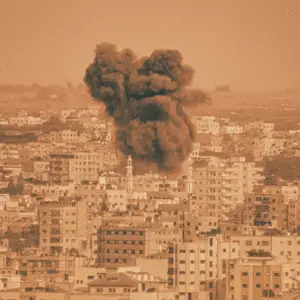A grainy, vintage-style image depicting a dense urban skyline with mid-rise buildings. A large, dark plume of smoke rises ominously from the city centre, suggesting a recent explosion. The image is rendered in a washed-out, sepia-orange tone, evoking a 1968 protest poster aesthetic with high contrast and nostalgic texture. A mosque minaret is visible among the buildings, hinting at the city's Middle Eastern setting.