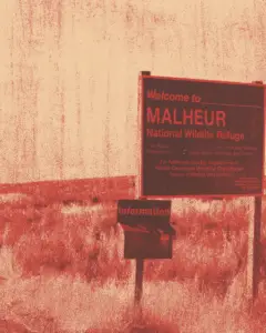 A graphic-styled image of the “Welcome to Malheur National Wildlife Refuge” sign, reimagined in a red and beige duotone. The sign stands in an arid landscape of scrubland and dry grasses, with an information box beneath it. The image has a grainy, textured overlay that evokes screen-printed posters or photocopied resistance flyers, giving it a raw, politicised aesthetic. The harsh red tones and washed-out background suggest heat, hostility, and defiance.