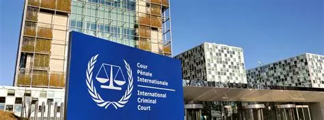 The International Criminal Court in The Hague, with the blue ICC sign in front of a modern glass building complex.