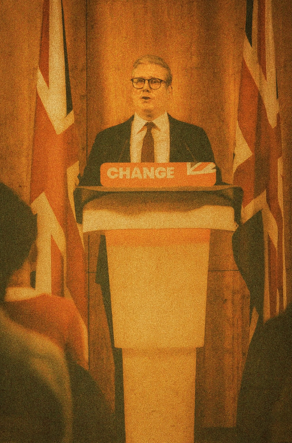 Labour leader Keir Starmer speaking at a podium marked ‘CHANGE,’ flanked by two Union Jack flags.
